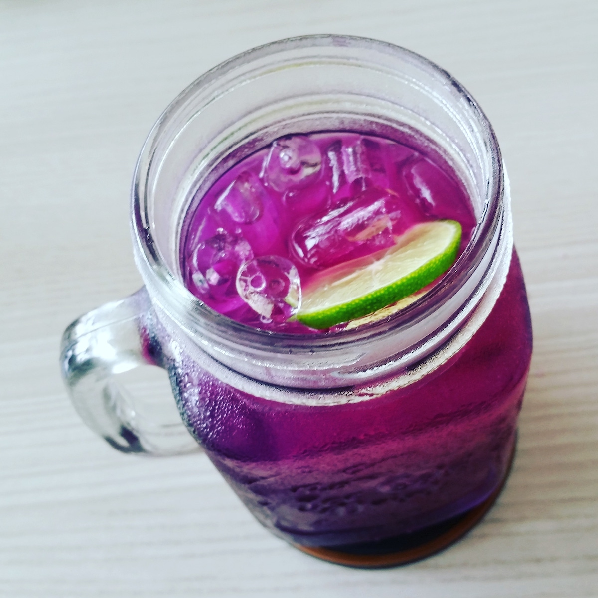 Purple Butterfly Pea Tea with Lime in Mason Jar Glass