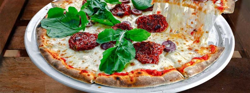 Rustic pizza with dried tomatoes, olives and buffalo mozzarella: an Italian journey