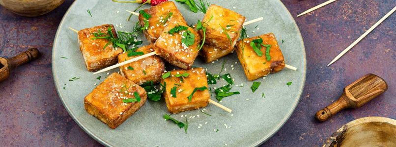 Tofu skewers in curry and sesame sauce
