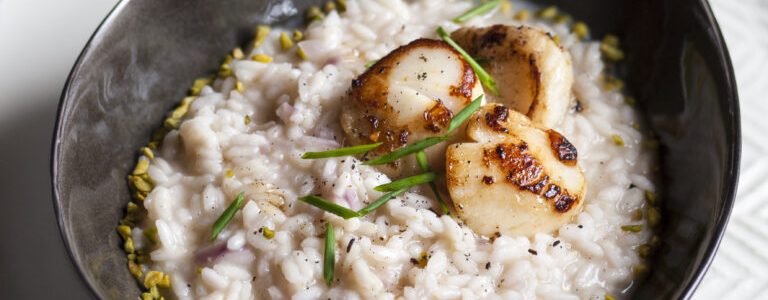 Vermouth risotto with scallops, lemon and vanilla flavored pistachios